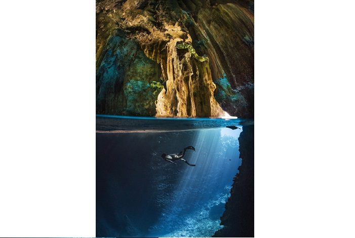 Un apnéiste solitaire nage dans la remarquable grotte des hirondelles aux Tonga. 2ème place portfolio - Matty Smith © Matty Smith - Ocean photography awards